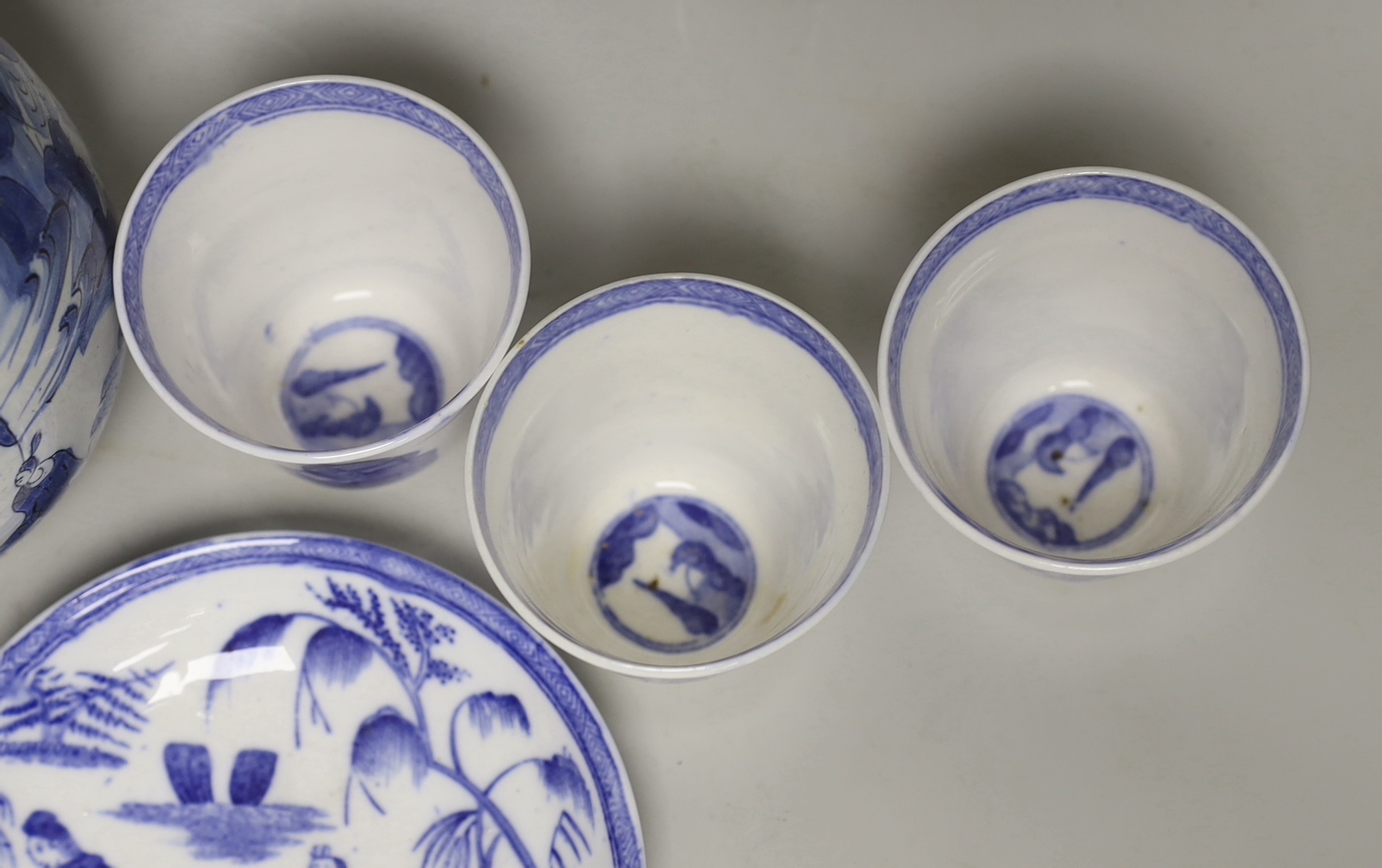 A late 17th century Delft blue and white ewer and three Chinese style tumblers and saucers, tallest 20cm